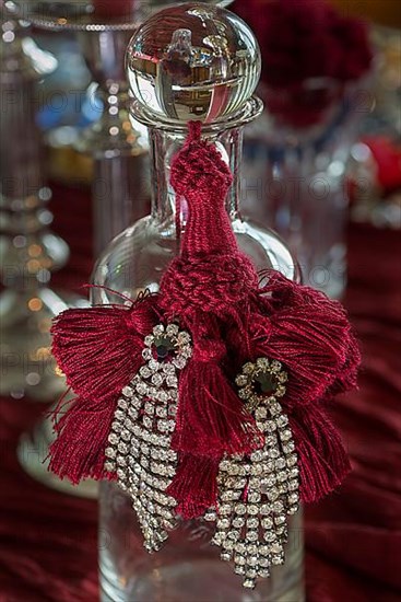 Rhinestone earrings decorated on a glass bottle, Bavaria