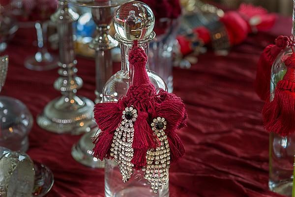 Rhinestone earrings decorated on a glass bottle, Bavaria