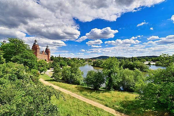 View over beautiful German city Aschaffenburg with Main river, palace called Schloss Johannisburg and green park on sunny summer day