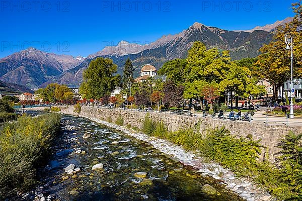 The river Passer flows along the spa garden and spa hotel of Merano, behind it the Mutspitze and mountains of the Texelgruppe