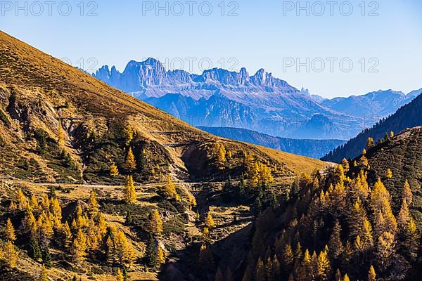 Hiking trail in autumnal mountain landscape, the mountain backdrop of the Dolomites in the background