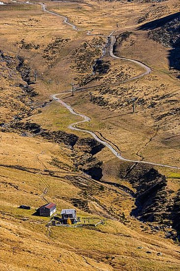 Winding hiking trail, in front a small mountain hut