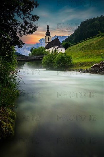 Parish church of St. Sebastian, with wooden bridge over a stream