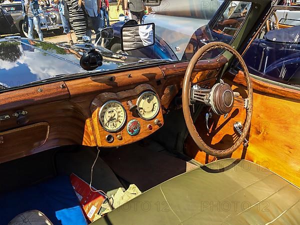 View on wooden dashboard with classic analogue round instruments of historic sports car convertible Triumph Roadster 2000 from 40s 1949, Classic Days