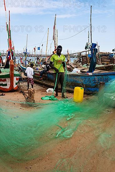 Fishermen mending nets, fishing boats