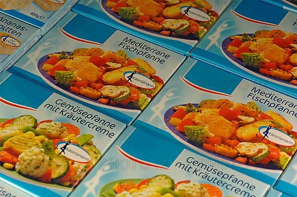 Frozen food, packages with vegetable pan with herb cream in the freezer in a supermarket
