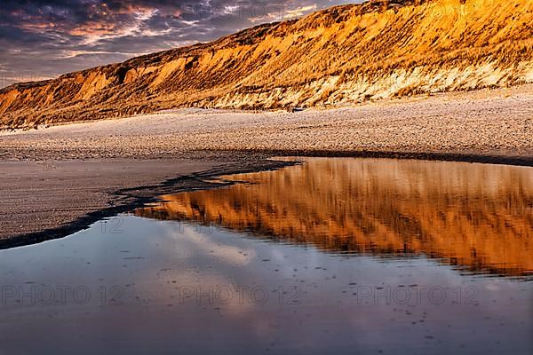 Red cliff reflected in the water