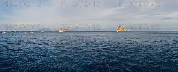 Le Guglie Island and di Basiluzzo of a former volcano and the volcanic island of Stromboli with anchored sailing ships
