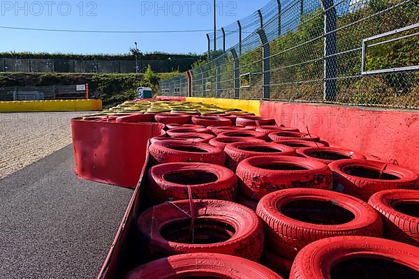 Safety measure for car racing Impact protection red yellow coloured tyre piles next to gravel bed in turn 8 of racetrack for motorsport