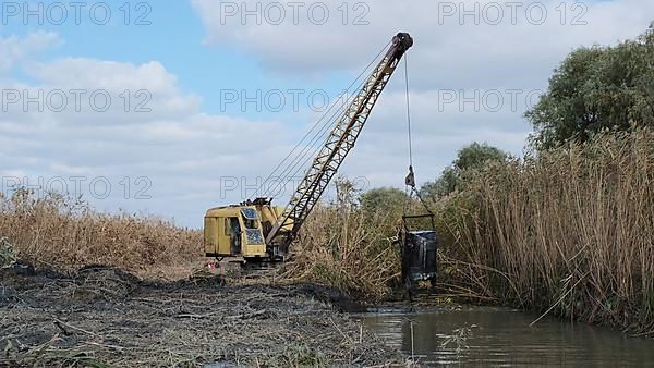 Excavator deepens and widens the canal between the Danube River and the lakes