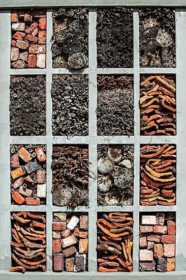 Insect hotel with artificial nesting facilities for solitary bees and cavities for hibernating ladybirds and other insects