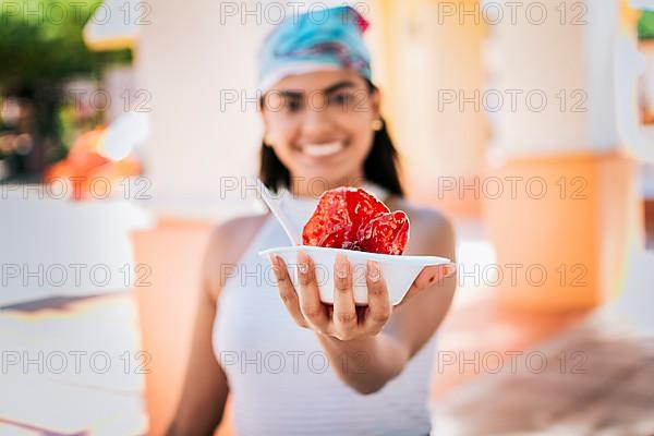 Close up of young woman holding a shaved ice in the street. Concept of a girl with a Nicaraguan raspado