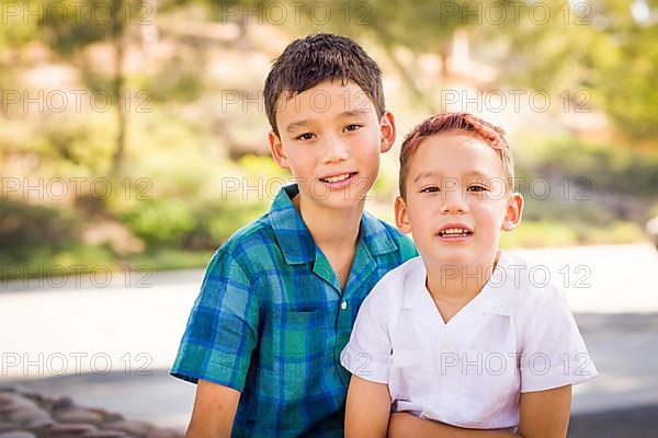 Outdoor portrait of biracial chinese and caucasian brothers