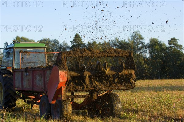 John Deere tractor pulling manure spreader