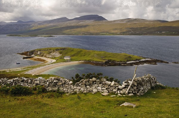 View of land in sea loch connected to mainland by tombolo promontory
