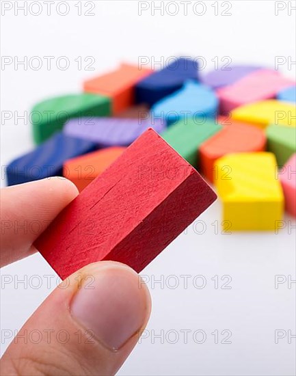 Colorful wooden pieces of a logic puzzle in hand