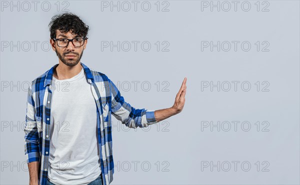 Displeased young man rejecting with rejection gesture