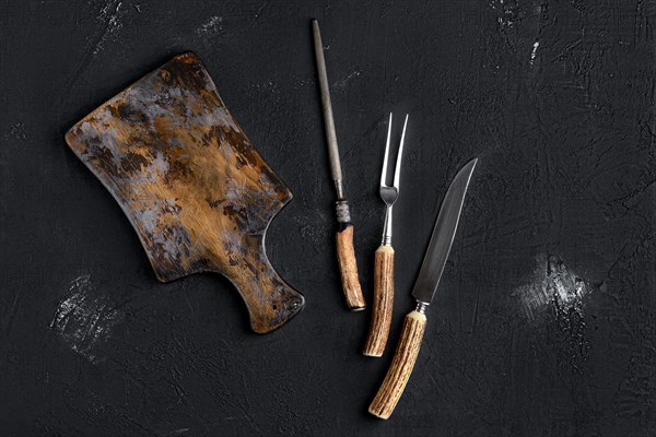 Rustic shabby cutting board with knife and fork for steak and knife sharpener