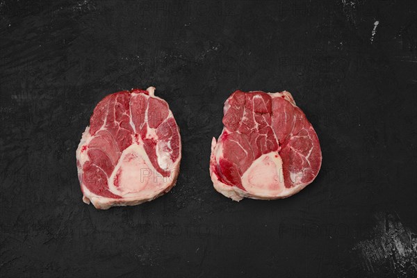 Raw beef ossobuco steak on black background