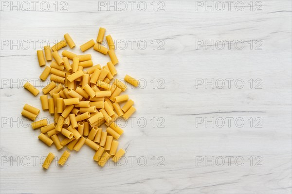 Overhead view of rigatoni pasta on wooden table