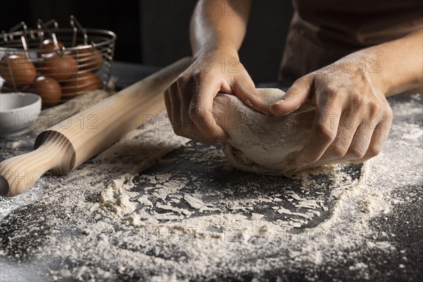 Chef kneading dough flour table