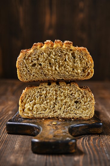 Fresh oats bread with sunflower seeds and sesame on wooden table