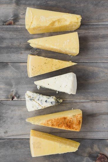 Triangular cheese chunk arranged row wooden plank. Resolution and high quality beautiful photo