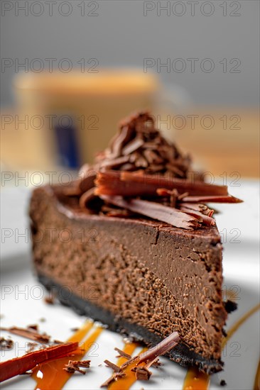 Macro photo of piece of chocolate cake with cappuccino