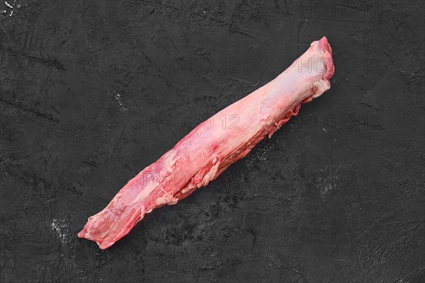 Top view of raw fresh pork fillet on black background