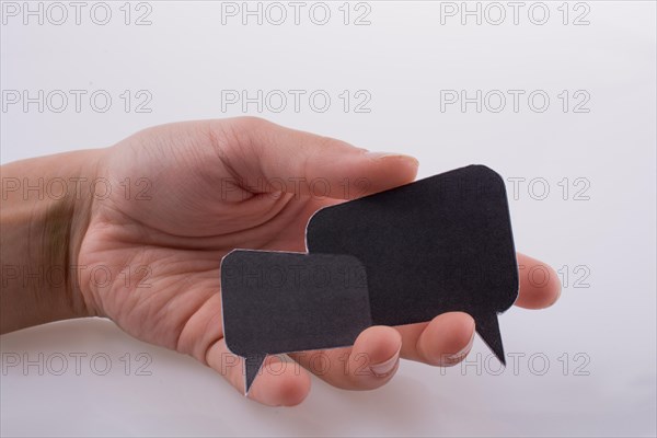 Hand holding dialogue boxes on a white background