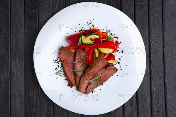 Top view of roasted beef cutted on slices with grilled bell pepper