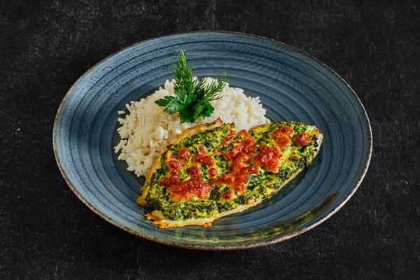 Fried fillet of white fish with spinach and cheese topping and served with rice