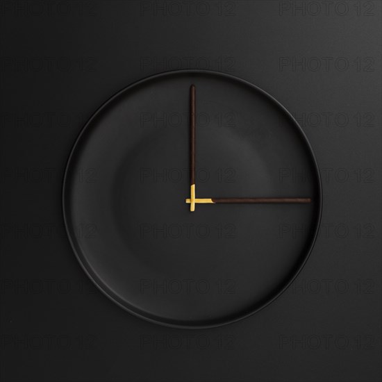 Dark plate with chocolate sticks form clock