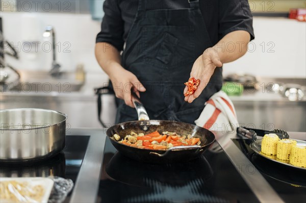 Male chef adding chili dish