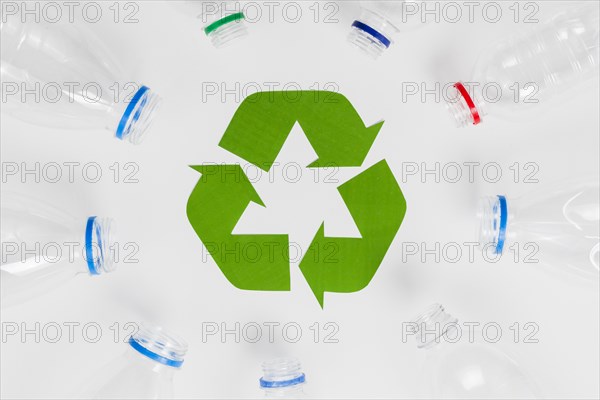 Empty plastic bottles around recycling icon
