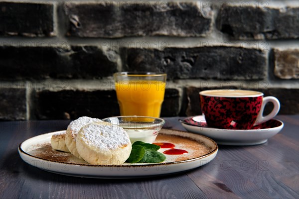 Traditional breakfast with cottage cheese pancake with sour cream