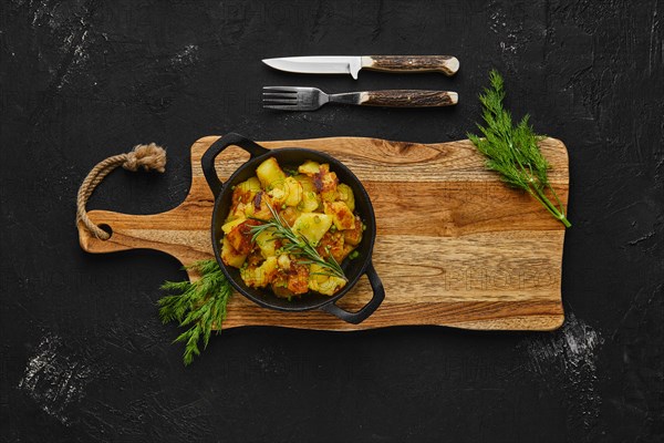 Top view of cast irom skillet with potato wedges baked in oven