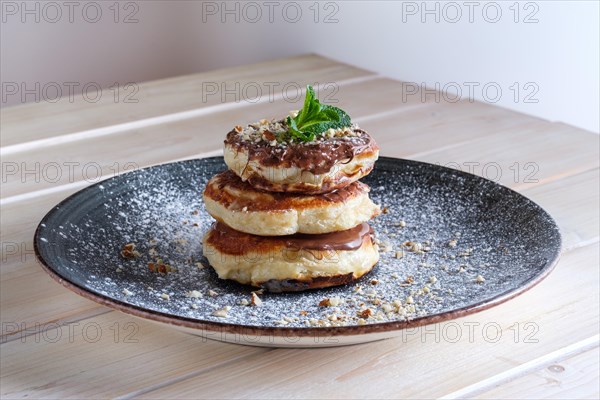 Fritters with peanut butter. Traditional Slavic pancakes with chocolate paste
