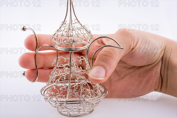 Silver color metal jug in hand a white background