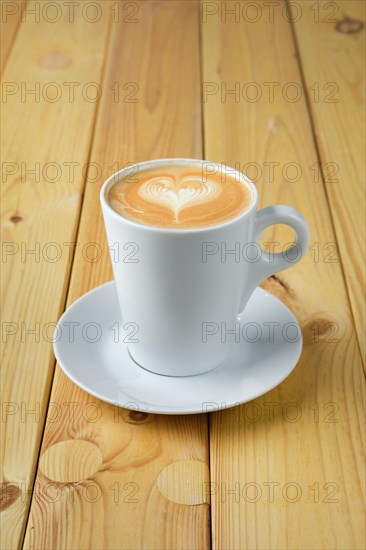 Cappuccino in ceramic cup on wooden table