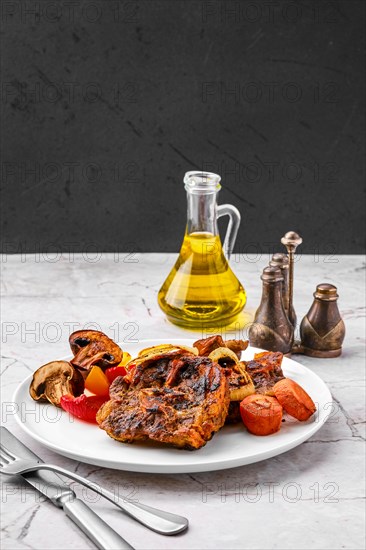 Lamb neck with champignon and vegetables baked in oven on a plate