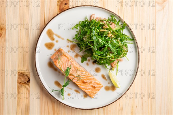 Steamed salmon with arugula and shrimps garnish