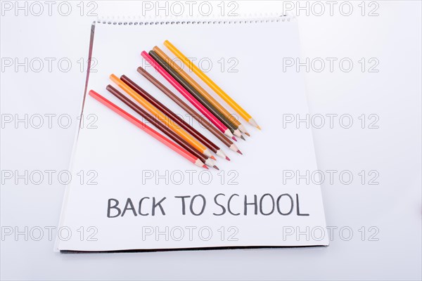 Color pencils and back to school title on a notebook