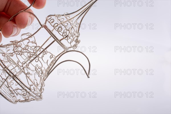 Silver color metal jug in hand a white background