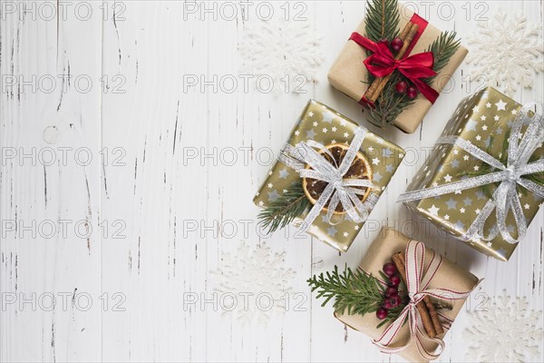 Collection of present boxes in christmas wrap between ornament snowflakes