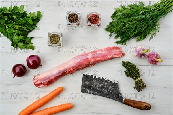 Top view of raw fresh pork fillet with spice on wooden background