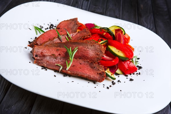 Roasted beef cutted on slices with grilled bell pepper