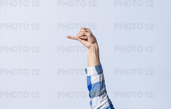 Hand gesturing the letter J in sign language on an isolated background. Man's hand gesturing the letter J of the alphabet isolated. Letters of the alphabet in sign language