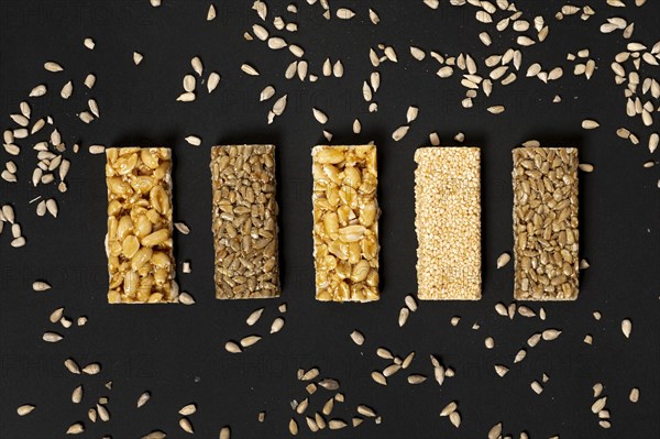 Flat lay cereal bars assortment with sunflower seeds plain background