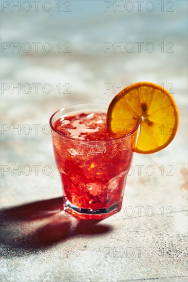 Cocktail boulevardier under sunlight with harsh shadows